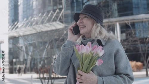 A mature woman talking by phone in the city
