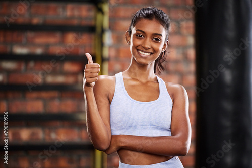 Portrait  thumbs up and woman in gym  training or exercise goals with wellness  proud of progress and support. Face  person or girl in health centre  hand gesture or promotion with challenge and like
