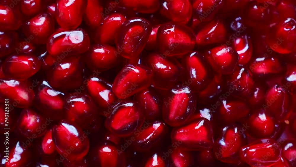 Bright red pomegranate seeds circle rotation close up top view