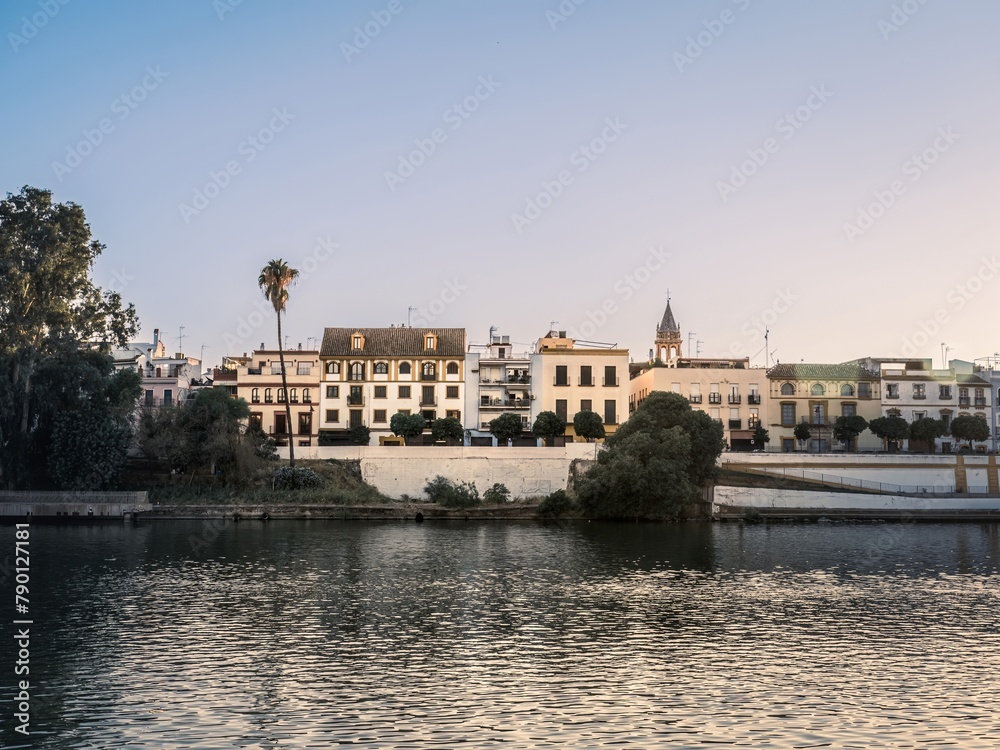 Colorful buildings including homes and shops face the Guadalquivir River in the Triana District of the Analusian city of Seville, Spain.