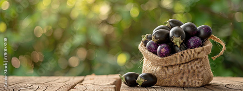 eggplants in burlap on a wooden table photo