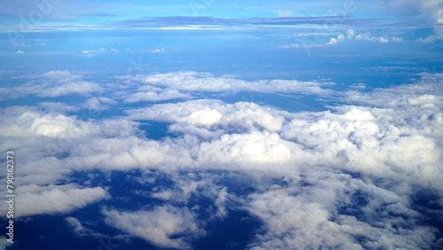 The earth and sky aerial view from the airplane. Blue sky and clouds. Blue summer sky with white clouds vibrant color background. Sky cloud natural backgrounds.