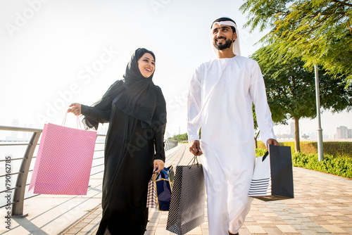 Arabic couple wearing kandura and abaya shopping in Dubai