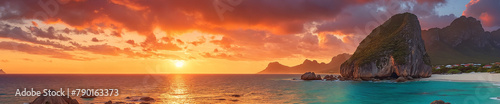 A beautiful sunset over a sea, with the sun setting on the horizon. The scene features a mountain range in the background, adding to the picturesque view. The sky is filled with clouds.