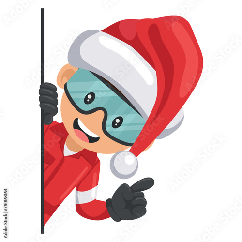 Industrial mechanical worker with Santa Claus hat peeking out from behind a wall pointing finger. Merry christmas. Express an idea and indicate it with the index finger
