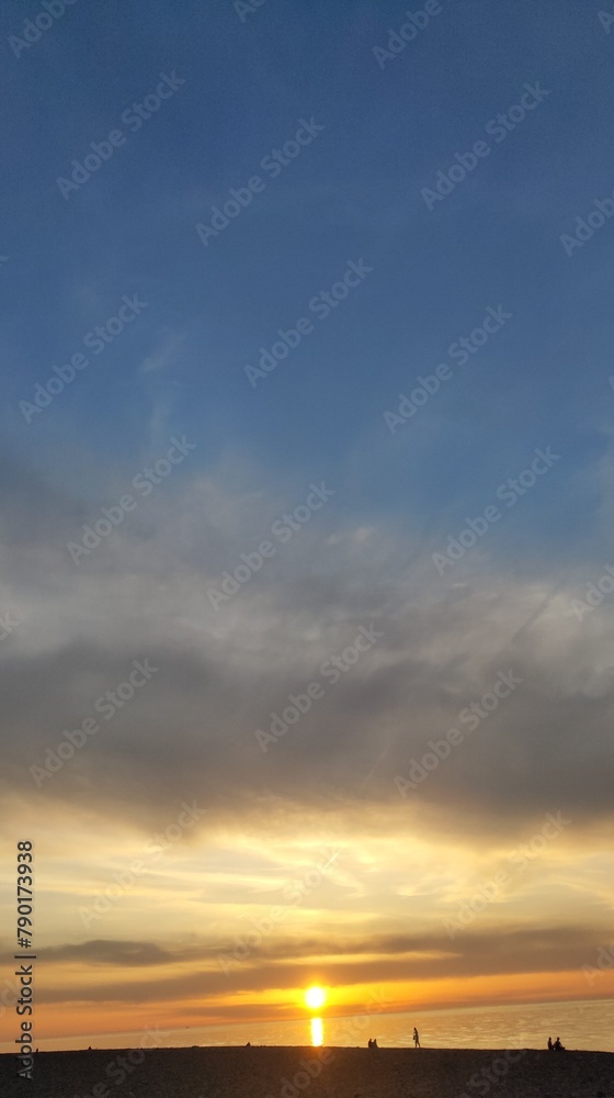 Golden hues paint the sky at seaside sunset Golden hues paint the sky at seaside sunset