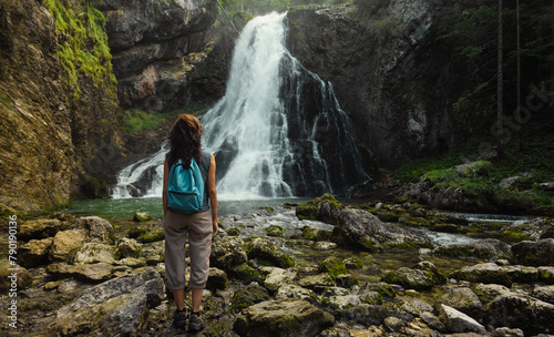 A woman standing at the Gollinger Waterfall in Torren, a district of Golling.