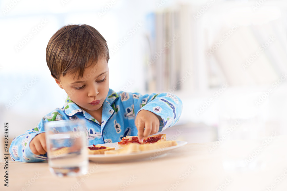 Young, male kid and eating breakfast at table for healthy, sandwich and hungry in house. Morning, food and water for meal at home with bread, glass and boy inside for snack, nutrition and vitality Young, male kid and eating breakfast at table for healthy, sandwich and hungry in house. Morning, food and water for meal at home with bread, glass and boy inside for snack, nutrition and vitality