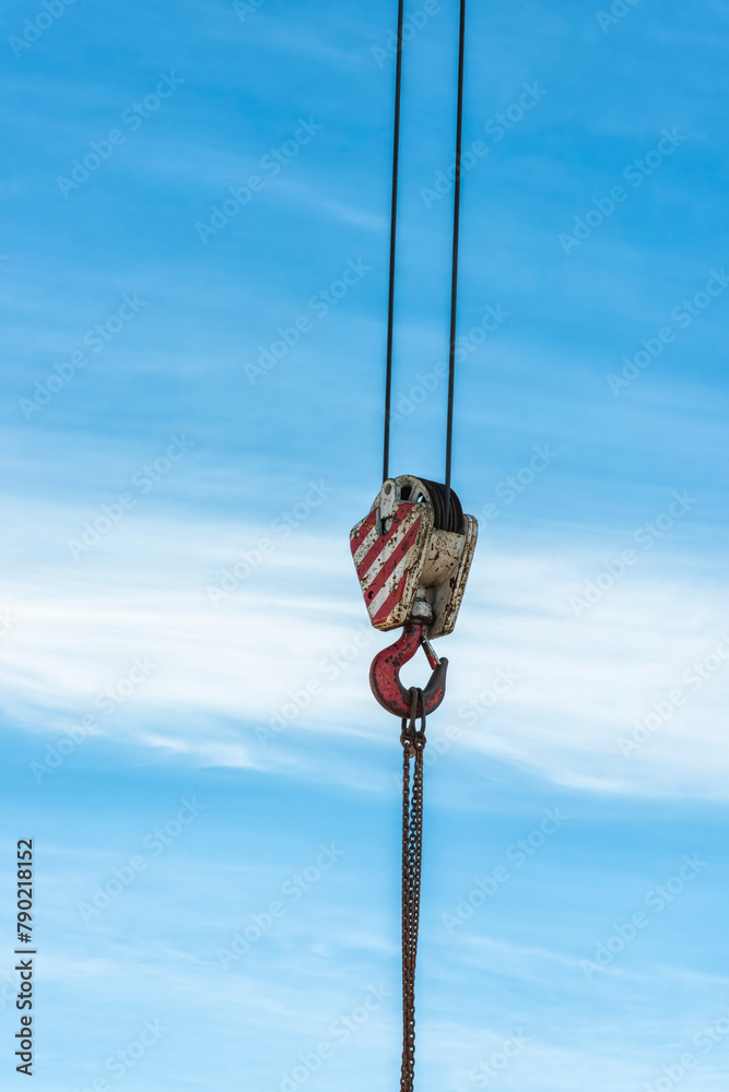 steel lifting hook of an industrial crane with a steel chain attached to it steel lifting hook of an industrial crane with a steel chain attached to it