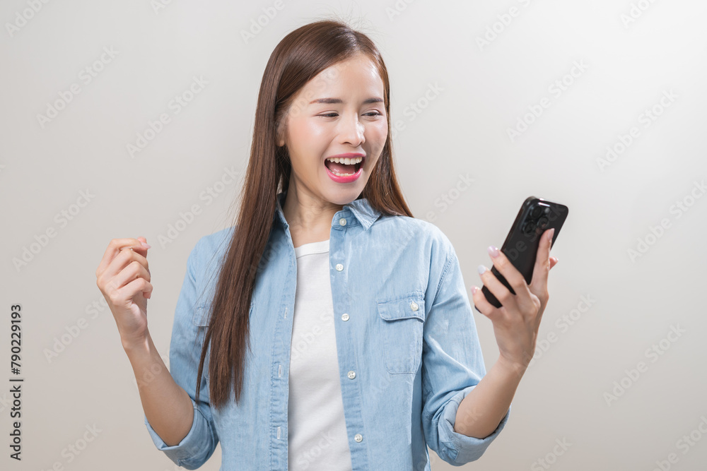 Happy with phone asian young woman, girl holding mobile smart phone, read good news winning feel excited getting offer, great positive surprise, celebrate success on smartphone isolated on background. Happy with phone asian young woman, girl holding mobile smart phone, read good news winning feel excited getting offer, great positive surprise, celebrate success on smartphone isolated on background.