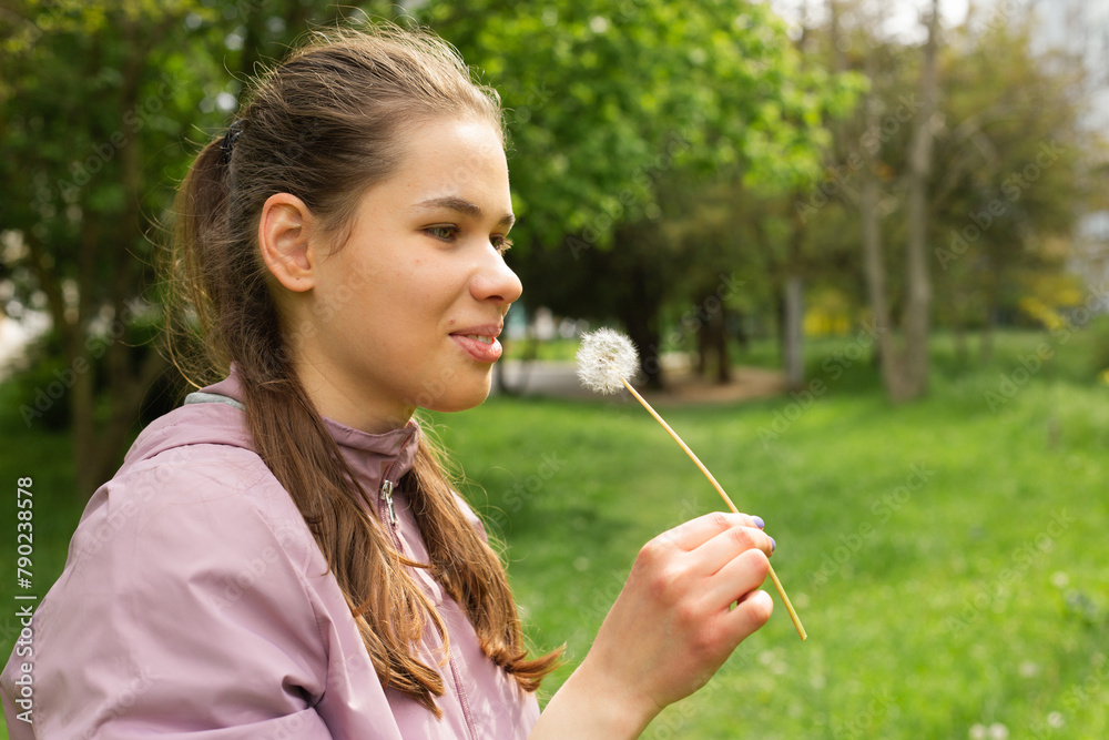 young child blowing dandelion
