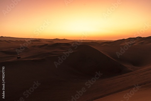 sunset over the dunes around huacachina in the Peruvian desert