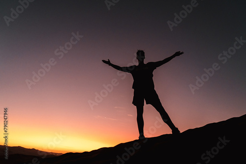 shadow of a man standing on a desert dune at sunset