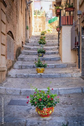 Colour flower pots lining the steps in the old town of Cefalu, Sicily