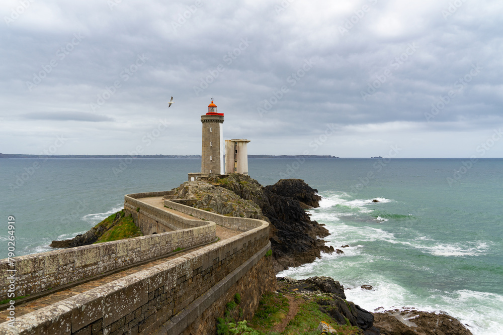 Une mouette survole gracieusement le phare du Petit Minou, ajoutant une touche de vie à la scène emblématique de l'entrée du goulet de Brest, dans la Mer d'Iroise, en Finistère.