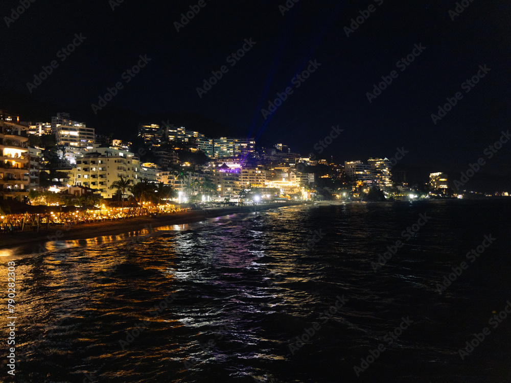 Horizontal view of the romantic zone seen from the water in Puerto Vallarta Mexico at night.