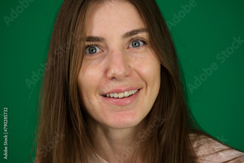 A studio close-up of a lovely young brunette with bright, warm smile.