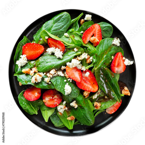 Summer salad of spinach, strawberries and blue cheese in a black plate isolated on a white background