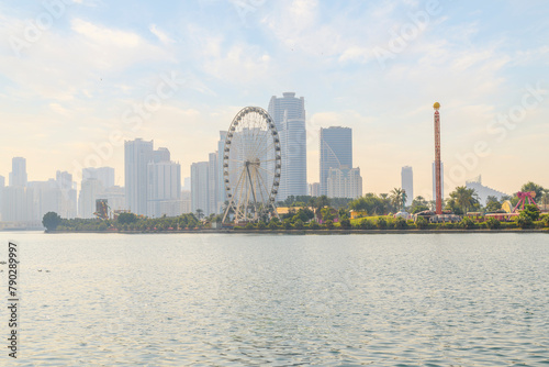 The skyline of downtown Sharjah and the Eye of the Emirates Ferris Wheel at Al Montazah Park island and amusement park, Sharjah, United Arab Emirates.	 photo