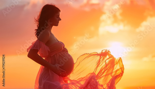 A pregnant woman is standing in a pink dress with a sun in the background