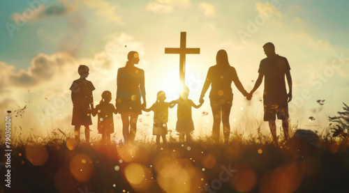 Cross, faith and prayer with family holding hands outdoor at sunset for belief, praise or worship together. God, Jesus and religion with silhouette of people praying for miracle from back at crucifix photo