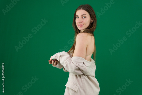 picture of beautiful topless woman in jeans covering breasts with hands gorgeous woman in a silver shiny dress on a green background chromakey sexuality femininity. sensuality  © Oleksandra