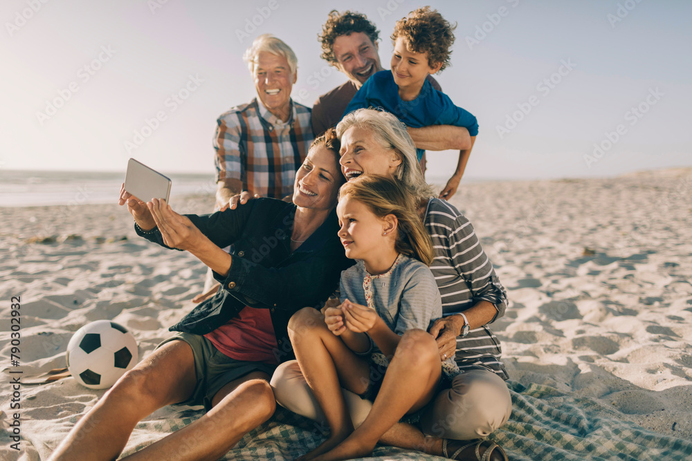 © Marko Geber - Happy family taking selfie on beach with soccer ball