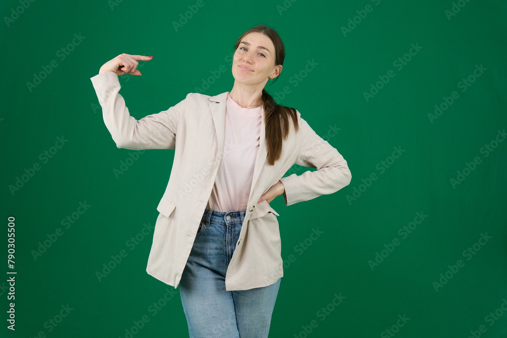 on a green background, chromakey, close-up of a woman with emotions in a beige jacket, red manicure, blue eyes