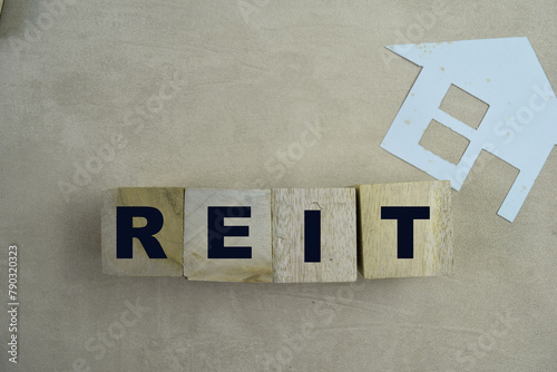 Concept of REIT - Real Estate Investment Fund The wooden Cubes with the word on wooden background.