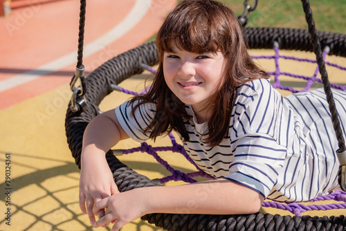 portrait of a happy smiling girl 11 years old playing on a children's playground.looks at the camera close-up. High quality photo