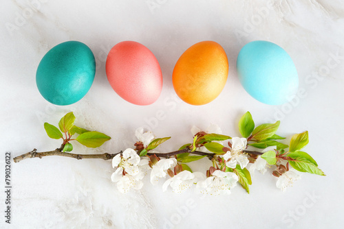 Easter postcard, painted Easter eggs lie on a marble countertop next to a blooming apple twig in close-up. Easter background, flat lay, minimalism © Маргарита Трушина