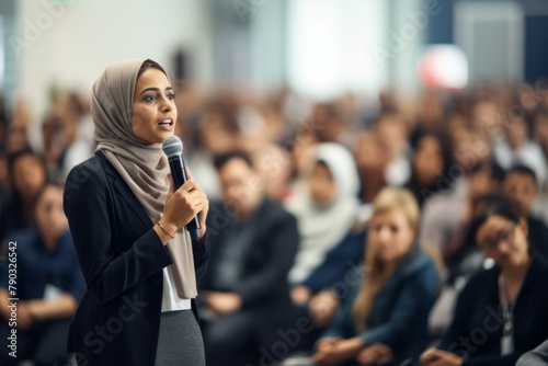 Female manager asking a question from audience while participating in business seminar at convention center.