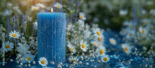 blue candle in the summer meadow with white daisy flowers.  photo