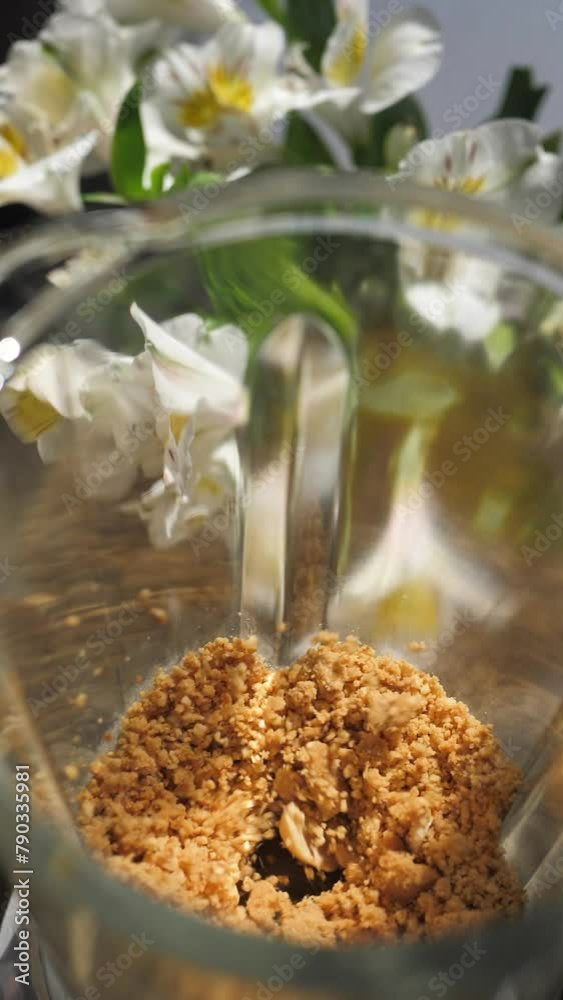 Vidéo Stock Vertically Grind the roasted peanuts using a glass blender