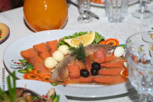 Sliced ​​salmon on a white plate with lemon