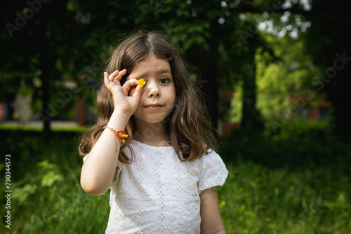 Portrait of a beautiful brunette Caucasian girl with a yellow flower.