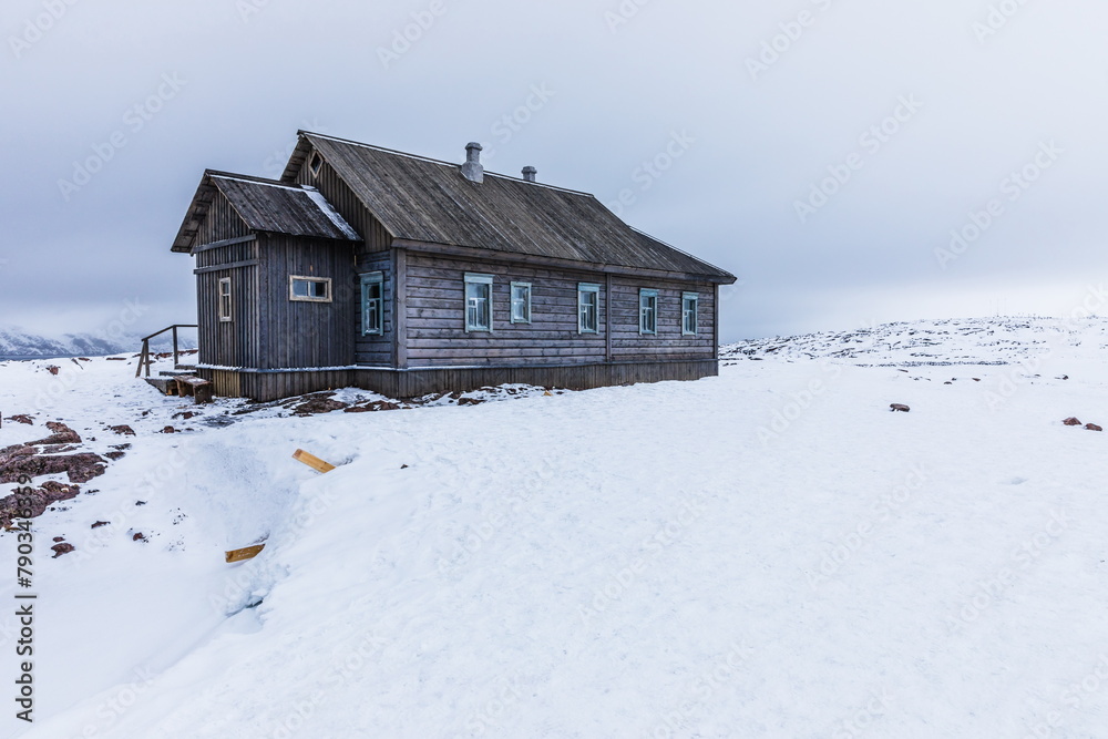 Wooden house in the polar northern landscape on the shore of the Barents Sea, Murmansk, Russia