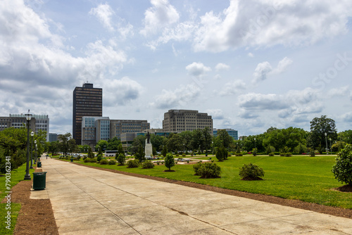 a beautiful spring landscape at Capitol Gardens with lush green trees, plants and grass, colorful flowers and office buildings in the skyline at the Louisiana State Capitol In Baton Rouge Louisiana © Marcus Jones