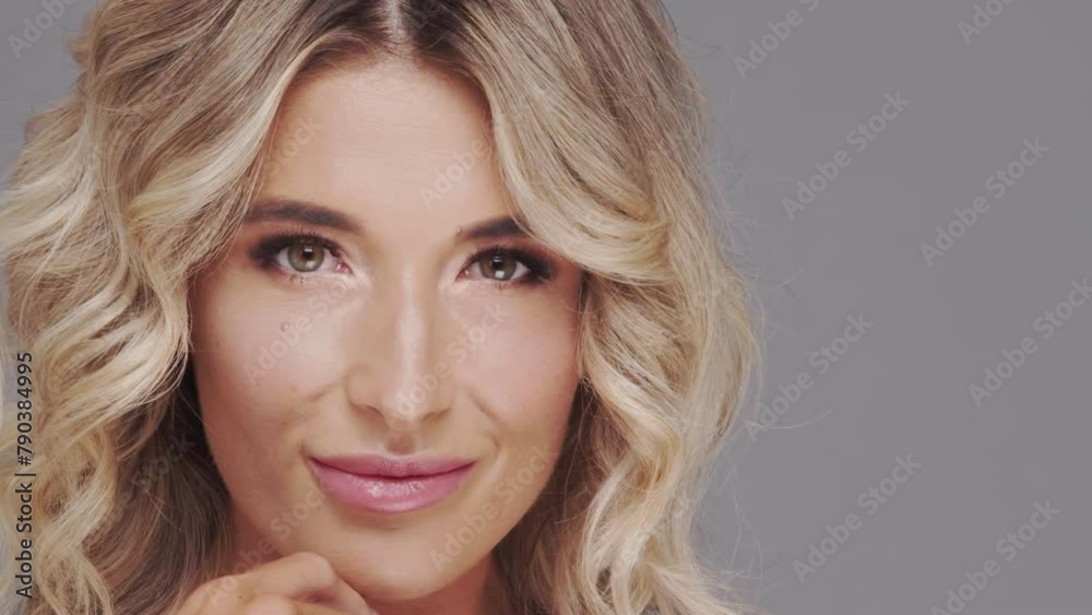 Studio portrait of young and beautiful blond woman over grey background. Skin care and wellness concepts.