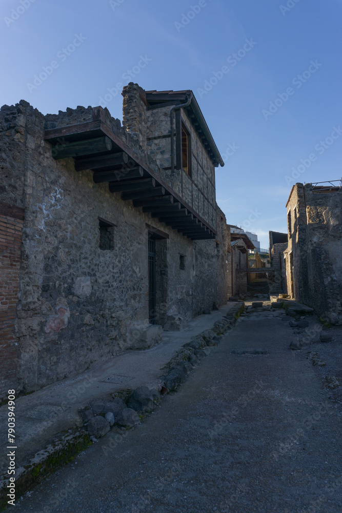 Roman street through the ruins during golden hour at sunset, Pompeii, Campania, Italy Roman street through the ruins during golden hour at sunset, Pompeii, Campania, Italy