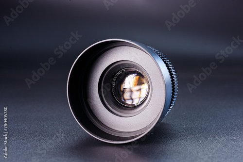 Close-up view of vintage Helios camera lens, black finish, photography gear on dark background, detailed focus rings visible, professional photographic equipment.