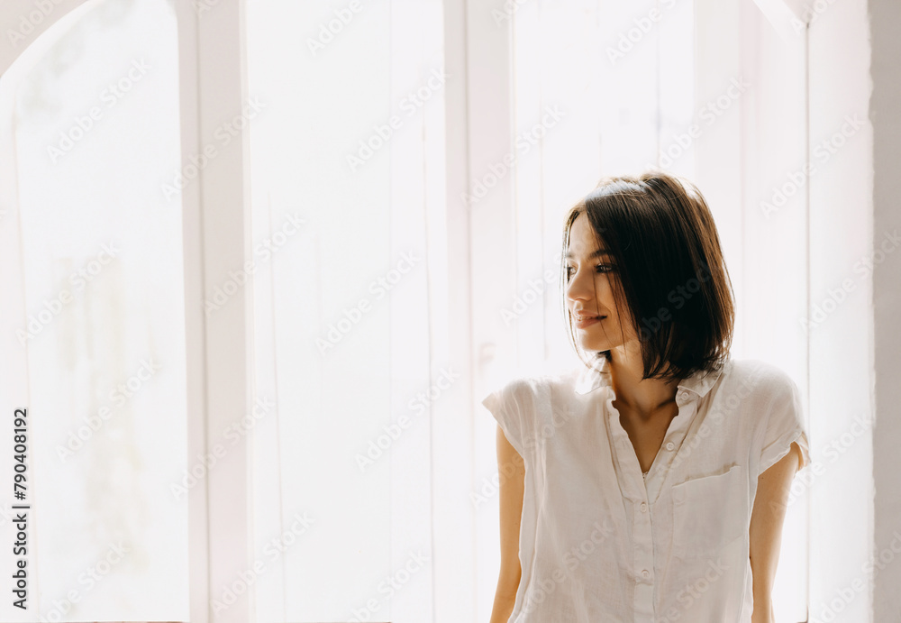 Smiling brunette woman in sunlit room by the window. Smiling brunette woman in sunlit room by the window.