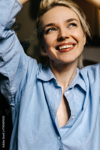 Happy candid moment of a young blonde woman smiling, closeup portrait.