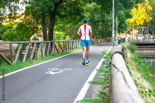 Senior Man Jogging in Park with wooden barriers in sportswear with determination
