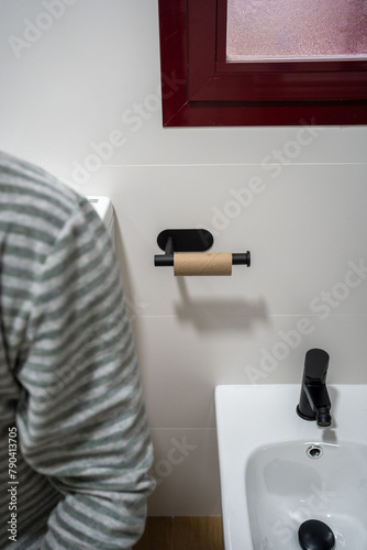 Unrecognizable man in the bathroom who has run out of toilet paper. Trouble for a man who is urgently using the toilet.