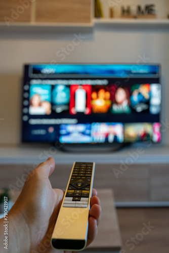 Εκτύπωση καμβά Hand of unrecognizable person holding remote control with television in front