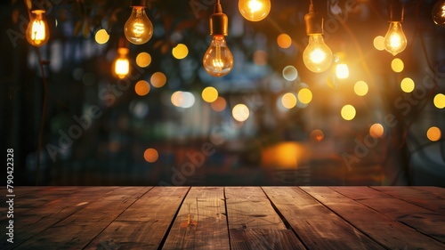 Hanging light bulbs above wooden table with blurred lights in background