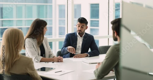 Serious middle-aged Indian businessman, company boss lead negotiation with partners or investors, discuss important business updates, strategic decision, project progress, corporate goals in boardroom