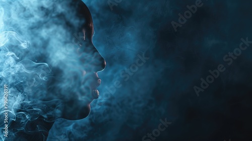 Silhouette of person exhaling smoke against dark blue background