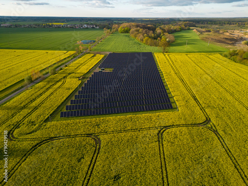 aerial view of solar power plant, environment friendy ecological electricity production on a beautiful farmland field on sunny afternoon